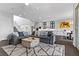 Open-concept design with living room flowing into the kitchen and dining area, featuring a large gray sectional at 6338 Skystone St, Las Vegas, NV 89135