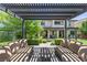 Serene outdoor patio with comfortable seating under a pergola, overlooking the manicured lawn and landscaping at 6338 Skystone St, Las Vegas, NV 89135