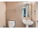 Cozy half bathroom featuring a pedestal sink and decorative mirror at 7267 W Mesa Vista Ave, Las Vegas, NV 89113