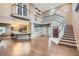 Bright, open living room with hardwood floors, a staircase, and an adjacent kitchen area at 7267 W Mesa Vista Ave, Las Vegas, NV 89113
