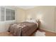 Bedroom featuring a window with blinds, a bed with a brown quilt, and wood-look flooring at 768 Lawrence Dr, Henderson, NV 89015