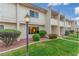 Inviting two-story condo featuring a well-kept lawn, colorful flower beds, and decorative outdoor lighting at 768 Lawrence Dr, Henderson, NV 89015