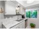 Modern kitchen with marble countertops, stainless steel dishwasher, and natural light at 768 Lawrence Dr, Henderson, NV 89015