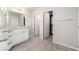 Bathroom with granite countertops, white cabinets, and tile flooring, with doorways to closet and other rooms at 7733 Rosebark Cliffs St, North Las Vegas, NV 89084