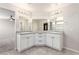 Bright bathroom featuring double sinks with granite countertop and white cabinets and modern lighting at 7733 Rosebark Cliffs St, North Las Vegas, NV 89084