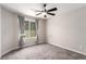 Neutral bedroom featuring modern ceiling fan, a window with gray curtains, and carpeted flooring at 7733 Rosebark Cliffs St, North Las Vegas, NV 89084