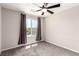 Neutral bedroom featuring modern ceiling fan, a window with dark curtains, and carpeted flooring at 7733 Rosebark Cliffs St, North Las Vegas, NV 89084