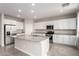 Modern kitchen featuring white cabinetry, stainless steel appliances, granite countertops and a large island at 7733 Rosebark Cliffs St, North Las Vegas, NV 89084
