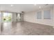 Open-concept living room with large windows, tile flooring, and natural light at 7733 Rosebark Cliffs St, North Las Vegas, NV 89084