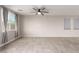 Spacious living room featuring tile flooring, a modern ceiling fan, and natural light from a large window at 7733 Rosebark Cliffs St, North Las Vegas, NV 89084