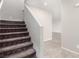 Carpeted stairs with white walls, leading to the upper level of the home with tile flooring at 7733 Rosebark Cliffs St, North Las Vegas, NV 89084