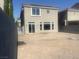 Unfinished backyard of a two-story home with gray walls, dirt, and block wall fence at 8116 Russell Creek Ct, Las Vegas, NV 89139