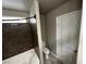 A clean bathroom features a white tub and shower with dark granite-look surround and a toilet at 8116 Russell Creek Ct, Las Vegas, NV 89139