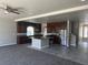 Open-concept kitchen with stainless steel appliances, dark wood cabinets, and an island with granite countertop at 8116 Russell Creek Ct, Las Vegas, NV 89139