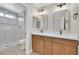 Modern bathroom featuring double sink vanity, wooden cabinets, and tiled shower with glass door at 8513 Festival Dr, Las Vegas, NV 89134