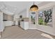 Modern kitchen featuring white cabinets, stainless steel appliances, and wood-look floors, flowing into a bright breakfast nook at 8513 Festival Dr, Las Vegas, NV 89134