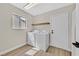 Well-lit laundry room with window, floating shelf, and washer and dryer at 8513 Festival Dr, Las Vegas, NV 89134