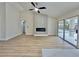 Open-concept living area with modern fireplace, wood-look floors, and sliding doors leading to an outdoor space at 8513 Festival Dr, Las Vegas, NV 89134