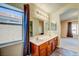 Bathroom featuring double sinks, warm lighting, and a large window at 8717 Tom Noon Ave # 101, Las Vegas, NV 89178