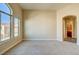 Cozy bedroom featuring new carpet, large windows, and an archway entrance to the bathroom at 8717 Tom Noon Ave # 101, Las Vegas, NV 89178
