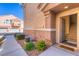 Home's entry door with welcome mat, desert landscaping, and proximity to three-car garage at 8717 Tom Noon Ave # 101, Las Vegas, NV 89178
