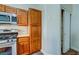 Well-lit kitchen with modern appliances, wooden cabinets, and a convenient pantry closet for organized storage at 8717 Tom Noon Ave # 101, Las Vegas, NV 89178
