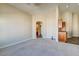 Spacious living room featuring neutral carpeting, cream walls, and an open floor plan leading to kitchen at 8717 Tom Noon Ave # 101, Las Vegas, NV 89178