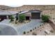 An aerial view of the home with a desert landscape, lovely backyard, and beautiful stone driveway at 9570 Thistle Creek Ave, Las Vegas, NV 89178