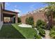 Lush backyard featuring artificial turf, patio, and beautiful desert landscaping at 9570 Thistle Creek Ave, Las Vegas, NV 89178