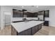 Beautiful, modern kitchen with dark cabinetry, stainless steel appliances, and a large island at 9570 Thistle Creek Ave, Las Vegas, NV 89178