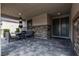 A covered outdoor patio with stone accents, a black patio set, and recessed lighting at 9570 Thistle Creek Ave, Las Vegas, NV 89178