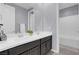 Bright bathroom with double sinks, white countertop, dark cabinetry, and separate tub and shower at 9654 Starfish Reef Way, Las Vegas, NV 89178