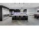 Open kitchen with stainless appliances, dark cabinetry, and a large granite island at 9654 Starfish Reef Way, Las Vegas, NV 89178