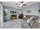 Living room with tile flooring, fireplace, ceiling fan and large sectional sofa at 9654 Starfish Reef Way, Las Vegas, NV 89178