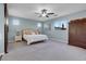 Comfortable main bedroom features a ceiling fan, soft carpet, and a sliding barn door at 9654 Starfish Reef Way, Las Vegas, NV 89178