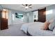 Comfortable main bedroom features a ceiling fan, soft carpet, and a sliding barn door to bathroom at 9654 Starfish Reef Way, Las Vegas, NV 89178