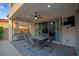 Spacious, covered patio featuring an outdoor kitchen, dining table, ceiling fan, and backyard access at 9654 Starfish Reef Way, Las Vegas, NV 89178