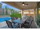 Covered outdoor dining area with a built-in grill, ceiling fan, and patio views at 9654 Starfish Reef Way, Las Vegas, NV 89178