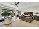 Elegant main bedroom boasts outdoor pool access, cozy seating, and modern furniture on wood floor at 10277 Roma Madre Ave, Las Vegas, NV 89135