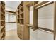 Custom walk-in closet with wooden shelves and drawers, plus chrome hardware and wooden floor at 10277 Roma Madre Ave, Las Vegas, NV 89135