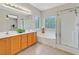 Well-lit bathroom has double sinks, a soaking tub, and a glass-enclosed shower at 11022 Saint Rafael St, Las Vegas, NV 89141
