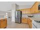 Bright kitchen with stainless steel refrigerator, oak cabinets, and tile flooring at 11022 Saint Rafael St, Las Vegas, NV 89141
