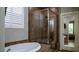 Bright bathroom with soaking tub, glass shower, and window with shutter, blending luxury and comfort at 11731 Longworth Rd, Las Vegas, NV 89135