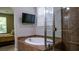 Well-lit bathroom featuring soaking tub, glass-enclosed shower, and neutral tile surround at 11731 Longworth Rd, Las Vegas, NV 89135