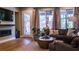 Cozy living room with a fireplace, plush sofa, large windows, and access to the backyard at 11731 Longworth Rd, Las Vegas, NV 89135