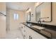 Modern bathroom with dual sinks, stylish fixtures, and elegant marble-look tile at 1501 Lucia Dr, Las Vegas, NV 89128
