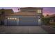 Two-story home with a three-car garage and a tile roof at dusk at 1501 Lucia Dr, Las Vegas, NV 89128