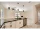 Modern kitchen island featuring black countertops, white cabinets, and stainless steel appliances overlooking the living space at 1501 Lucia Dr, Las Vegas, NV 89128