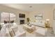 Staged living room with fireplace, sofa, chairs, rug, and backyard view at 1501 Lucia Dr, Las Vegas, NV 89128