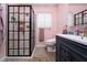 Well-lit pink bathroom featuring a modern shower with black grid doors and updated vanity at 18480 State Hwy 160, Las Vegas, NV 89161